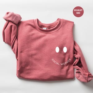 a pink sweater with a face drawn on it