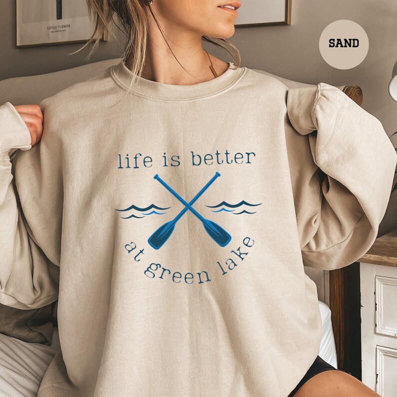 a woman wearing a sweatshirt that says life is better at green lake