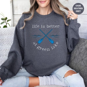 a woman wearing a sweatshirt that says life is better at green lake