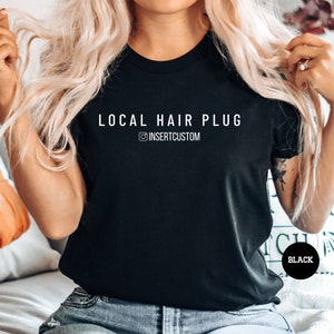 a woman sitting on a bed wearing a black local hair plug shirt