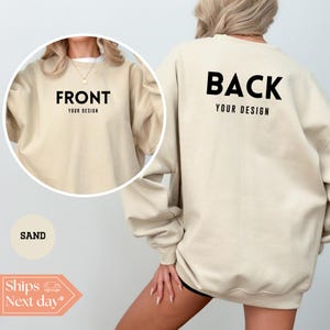 May include: Sand-colored sweatshirt with the words "FRONT" and "BACK" printed in black. The text "YOUR DESIGN" is below both words. The sweatshirt is shown on a person. The word "SAND" is in a circle. The image also includes a graphic that says "Ships Next day".