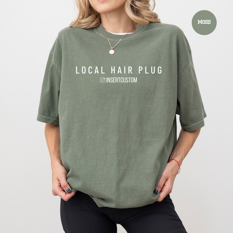 a woman wearing a green local hair plug t - shirt