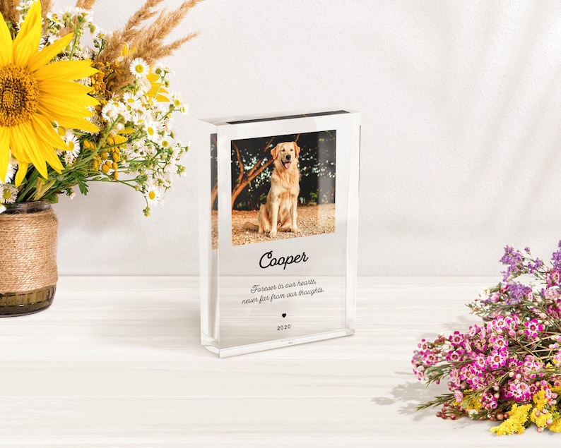 May include: A clear acrylic photo block with a picture of a golden retriever dog. The block has the dog's name "Cooper" and the text "Forever in our hearts, never far from our thoughts. 2020" printed on it.