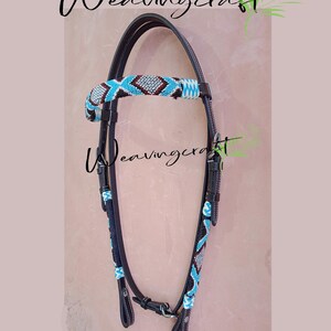 May include: A black leather horse bridle with turquoise and silver beadwork accents. The browband and cheekpieces feature intricate bead designs. The text "Weavingcraft" is displayed in cursive.