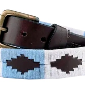 May include: A brown leather belt with a brass buckle and a blue and white woven strap with a repeating pattern.