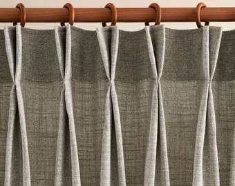 May include: Close-up of a set of gray curtains with pleats hanging from a wooden rod.