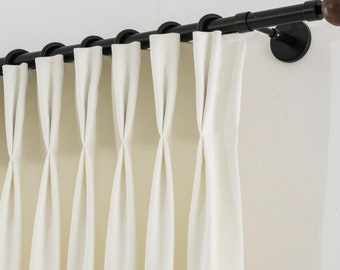 May include: Black curtain rod with wooden finials and white curtains hanging from it.