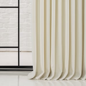 May include: Close-up of a white curtain with pleats, showing the texture of the fabric.