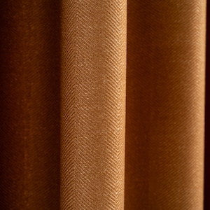 May include: Close-up of brown fabric curtains with a herringbone pattern.