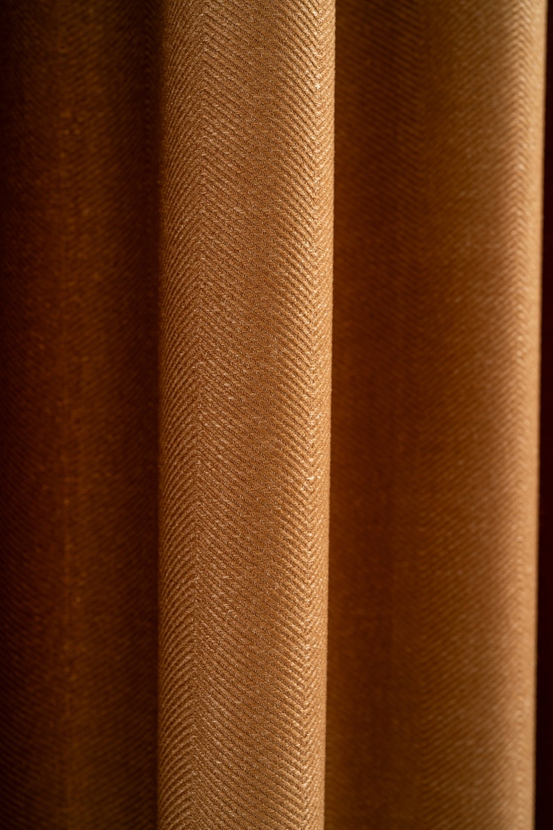 May include: Close-up of brown fabric curtains with a herringbone pattern.
