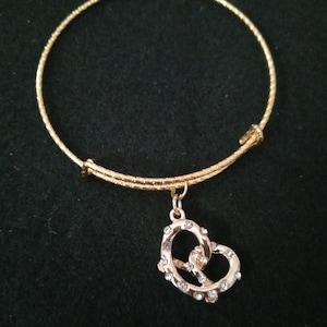 Gold cut adjustable bracelet with blinged pretzel charm.