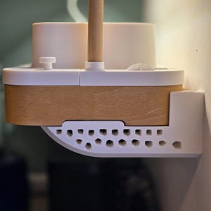 Può includere: Uno scaffale a parete bianco e legno a forma di barca con un albero di legno. Lo scaffale ha un design decorativo perforato sul fondo.