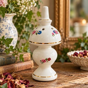 Vintage keramische pomander met bloemenmotief en potpourri-houder met gouden rand en geurverspreider.