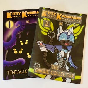 Puede incluir: Dos cómics con portadas negras e ilustraciones coloridas. El primer cómic se titula "Kitty Kommando: Cosmic Crusaders" con un monstruo de tentáculos púrpura en la portada. El segundo cómic se titula "Kitty Kommando: Cosmic Crusaders #2 The Garbic Collector" con un gato con un traje espacial azul y blanco en la portada.