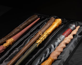 May include: Five wooden wands in a black velvet-lined box. The wands are different colors and have unique designs.