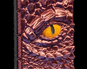 May include: A red and purple dragon scale-covered journal with a single yellow eye. The journal has a black spine and is closed.