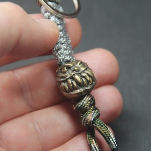 Scary Face Paracord Keychain – Handmade Brass Lanyard Bead with Reflective Braided Cord