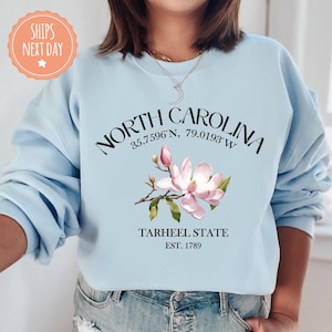 a woman wearing a north carolina sweatshirt and jeans