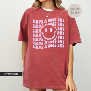a woman wearing a red shirt that says have a good day have a good day