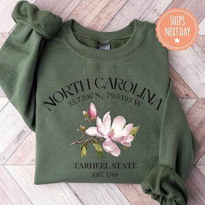 a green sweatshirt with a pink flower on it