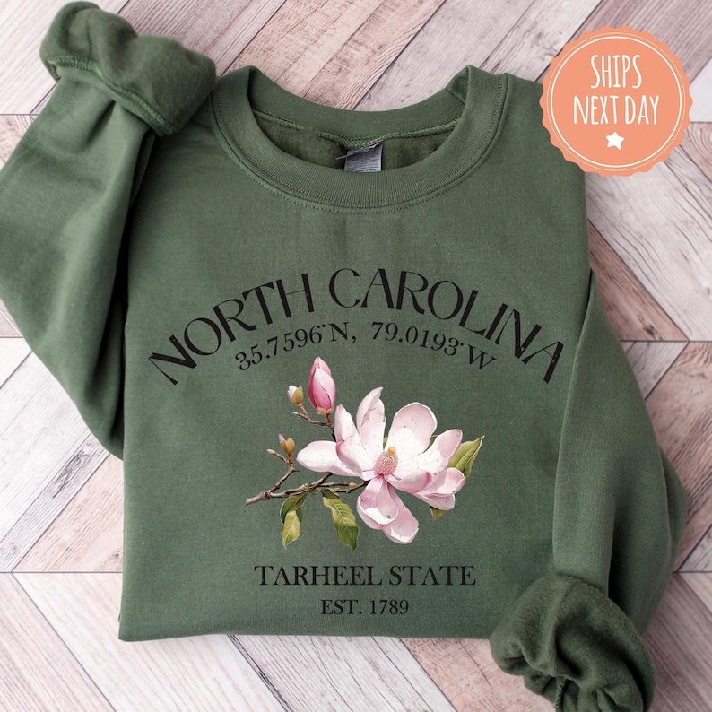 a green sweatshirt with a pink flower on it