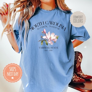 a woman wearing a blue north carolina t - shirt