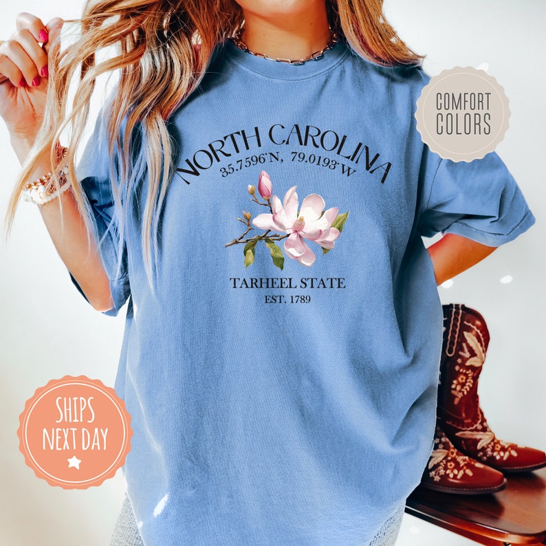 a woman wearing a blue north carolina t - shirt
