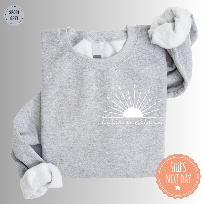 a grey sweatshirt with a white sun on it