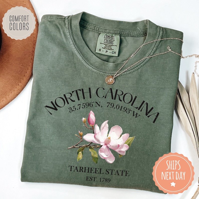 a green shirt with a pink flower on it