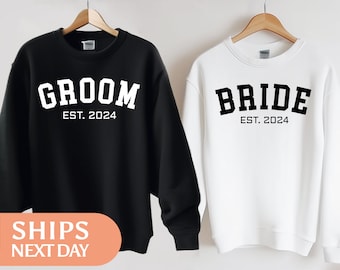 Peut inclure: Deux sweats-shirts noirs et blancs avec les mots "Groom Est. 2024" et "Bride Est. 2024" imprimés dessus.