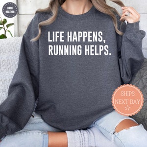 May include: Dark heather grey sweatshirt with the text "LIFE HAPPENS, RUNNING HELPS."