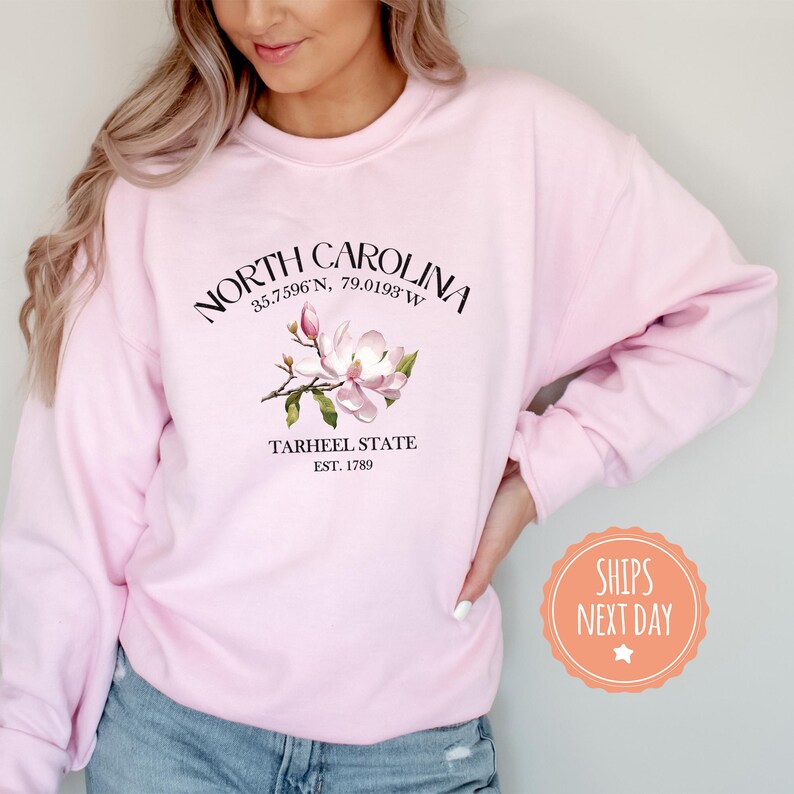 a woman wearing a pink north carolina sweatshirt