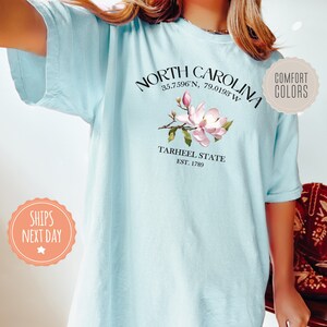 a woman is wearing a north carolina t - shirt