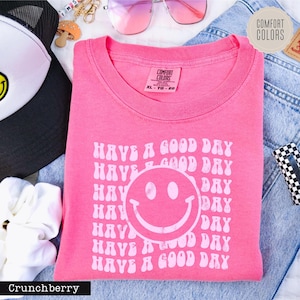 a pink shirt with a smiley face on it
