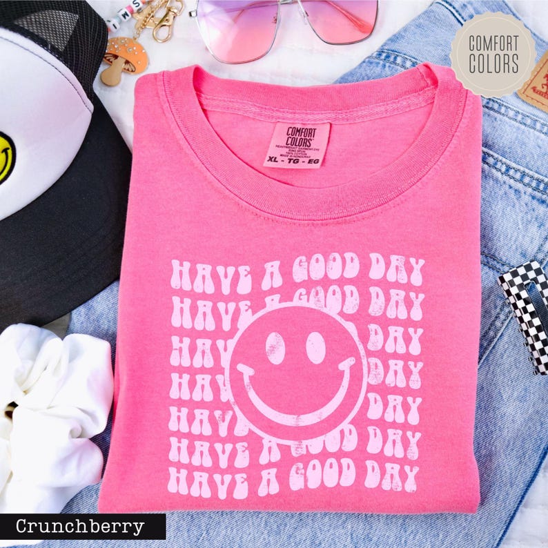 a pink shirt with a smiley face on it