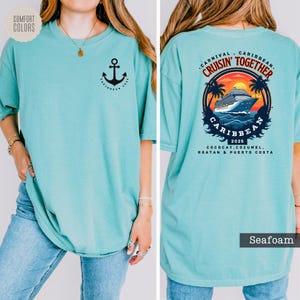 a woman wearing a turquoise shirt with an anchor on it