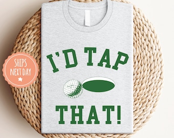 May include: Gray t-shirt with green text that reads "I'd Tap That!" and a green golf ball next to a green golf hole.