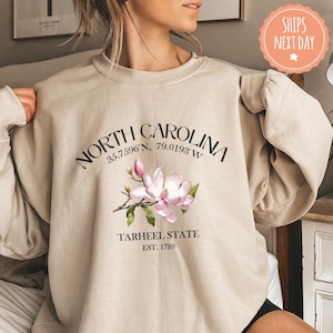 a woman is wearing a north carolina sweatshirt