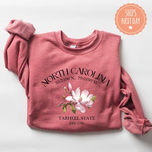a pink shirt with a pink flower on it
