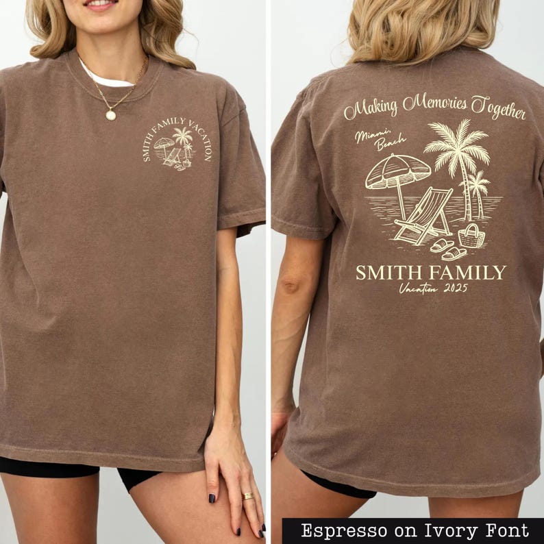 A woman wearing a brown t-shirt with a graphic design on the back, depicting a beach scene with a palm tree, beach chair, and umbrella.