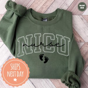 A green sweatshirt with the word "NICU" printed on it, along with a pair of baby feet.
