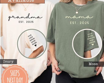 May include: An ivory t-shirt with black text reading grandma EST. 2025 and a moss green t-shirt with cream text reading mama EST. 2025. Both sleeves feature a list of names printed vertically above a small heart icon in matching colors.