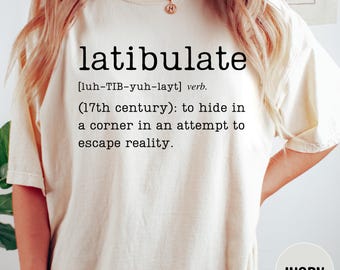May include: Ivory-colored t-shirt with the word "latibulate" printed in black, along with its pronunciation and definition. The definition reads: "to hide in a corner in an attempt to escape reality."