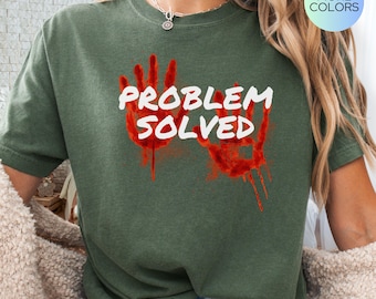 May include: A green t-shirt with the text "PROBLEM SOLVED" in white lettering. Two red handprints with dripping blood are behind the text.
