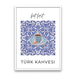 Könnte beinhalten: Ein weißer gerahmter Druck mit einem blauen und weißen gemusterten Hintergrund. Der Druck zeigt eine kleine weiße Kaffeetasse mit einem rosa türkischen Genuss auf einem weißen Unterteller. Der Text "but first" befindet sich oben auf dem Druck und "TÜRK KAHVESI" unten.