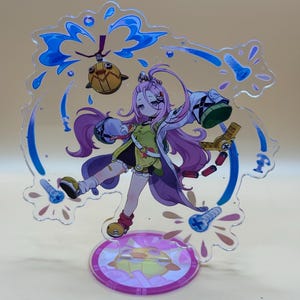 Puede incluir: Figura acrílica transparente de anime con un personaje femenino de pelo morado, vestida con un atuendo verde y blanco. La figura está sobre una base circular con un diseño rosa y blanco. Formas azules en forma de agua rodean al personaje.