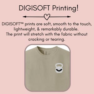May include: A light beige t-shirt with a black and white kettlebell graphic. The text "DIGISOFT Printing!" is above the image. The text "DIGISOFT&trade; prints are soft, smooth to the touch, lightweight, & remarkably durable. The print will stretch with the fabric without cracking or tearing." is below the image.