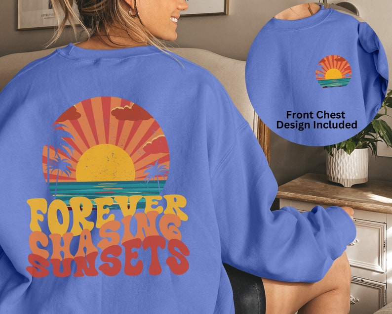 Puede incluir: Una sudadera azul claro con un gr&aacute;fico de puesta de sol retro y el texto "FOREVER CHASING SUNSETS" impreso en la espalda. La parte delantera de la sudadera presenta una versi&oacute;n m&aacute;s peque&ntilde;a del gr&aacute;fico de puesta de sol.