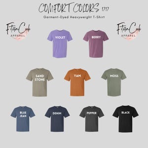 May include: A collection of ten t-shirts in various colors, including violet, berry, sand stone, yam, moss, blue jean, denim, pepper, and black. Each t-shirt has a different color and a white text label with the color name.