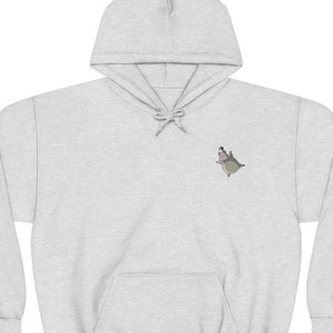 Op de afbeelding: Een grijs hoodie met een klein geborduurd beeld van een cartoonfiguur op de linkerborst.